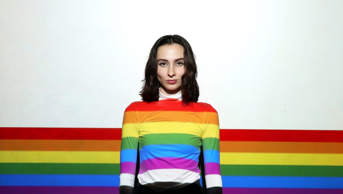 woman with LGBTQ flag accros her body